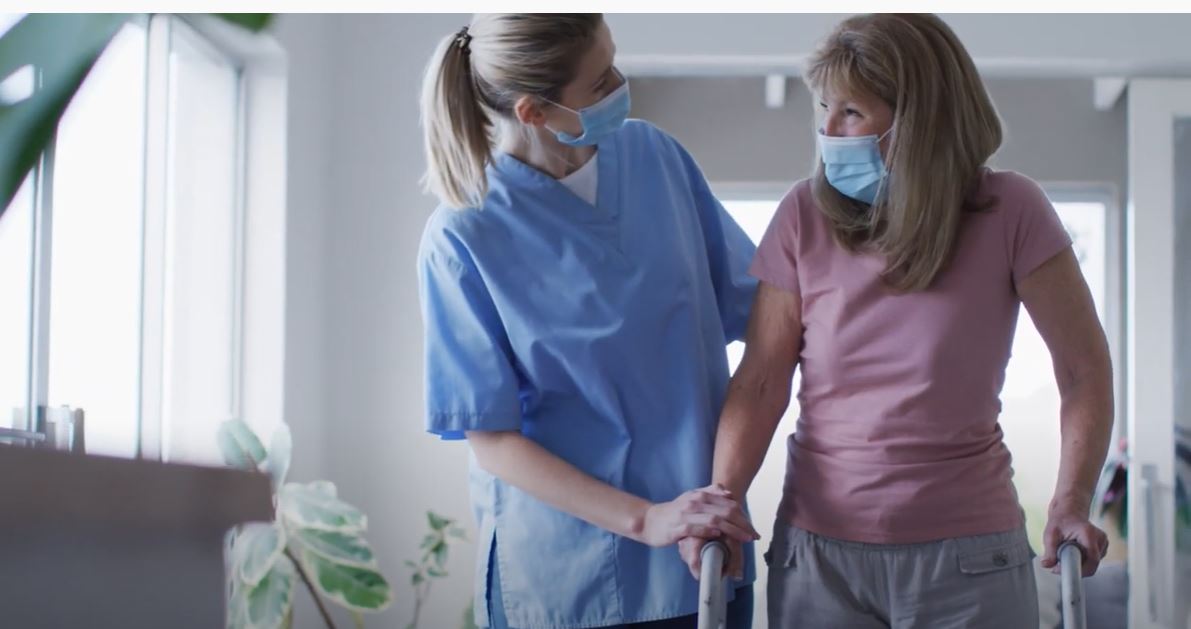 Caretaker Assisting Woman using a Walker