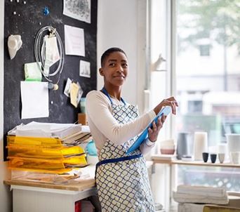 woman in art studio holding clipboard