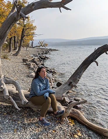 Stroke survivor, Flannery O’Neil, enjoying a quiet moment at the lake with mountains in the background.