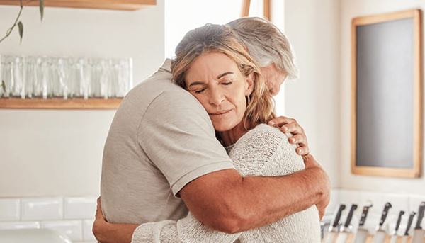 Husband and wife embracing in the kitchen