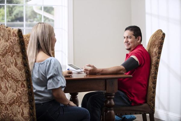 Man checking blood pressure at dining room table