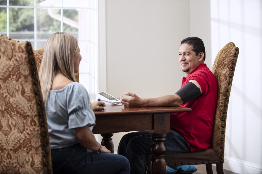 Man checking blood pressure at dining room table